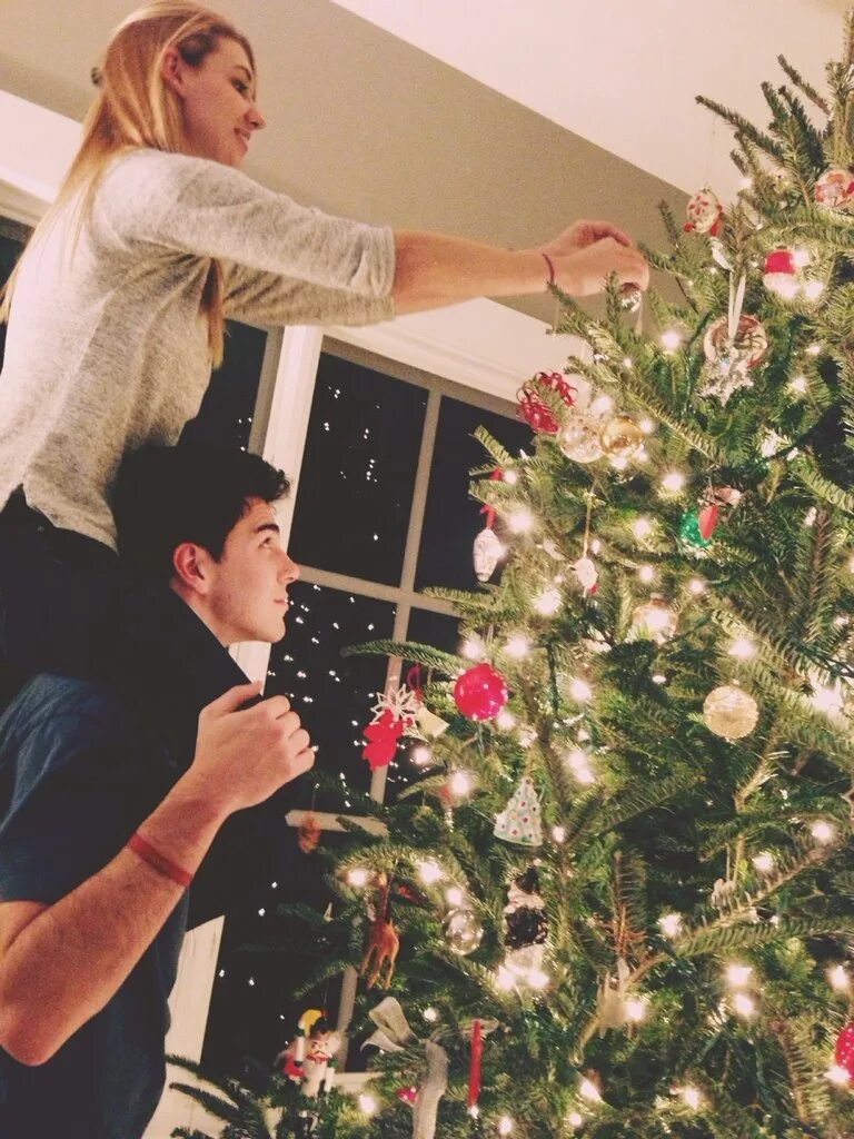 Украшают мужика. Наряжаем елку. Новый год с любимым человеком. Парень наряжает елку. Парень с девушкой украшают елку.
