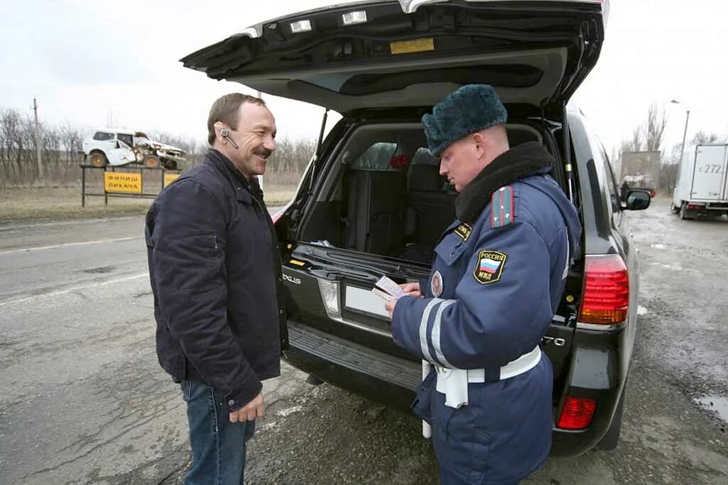 Досмотр гибдд. Досмотр автомобиля сотрудником ДПС. Что в багажнике ДПС. Гаишник осматривает машину. Гаишник вскрывает автомобиль.