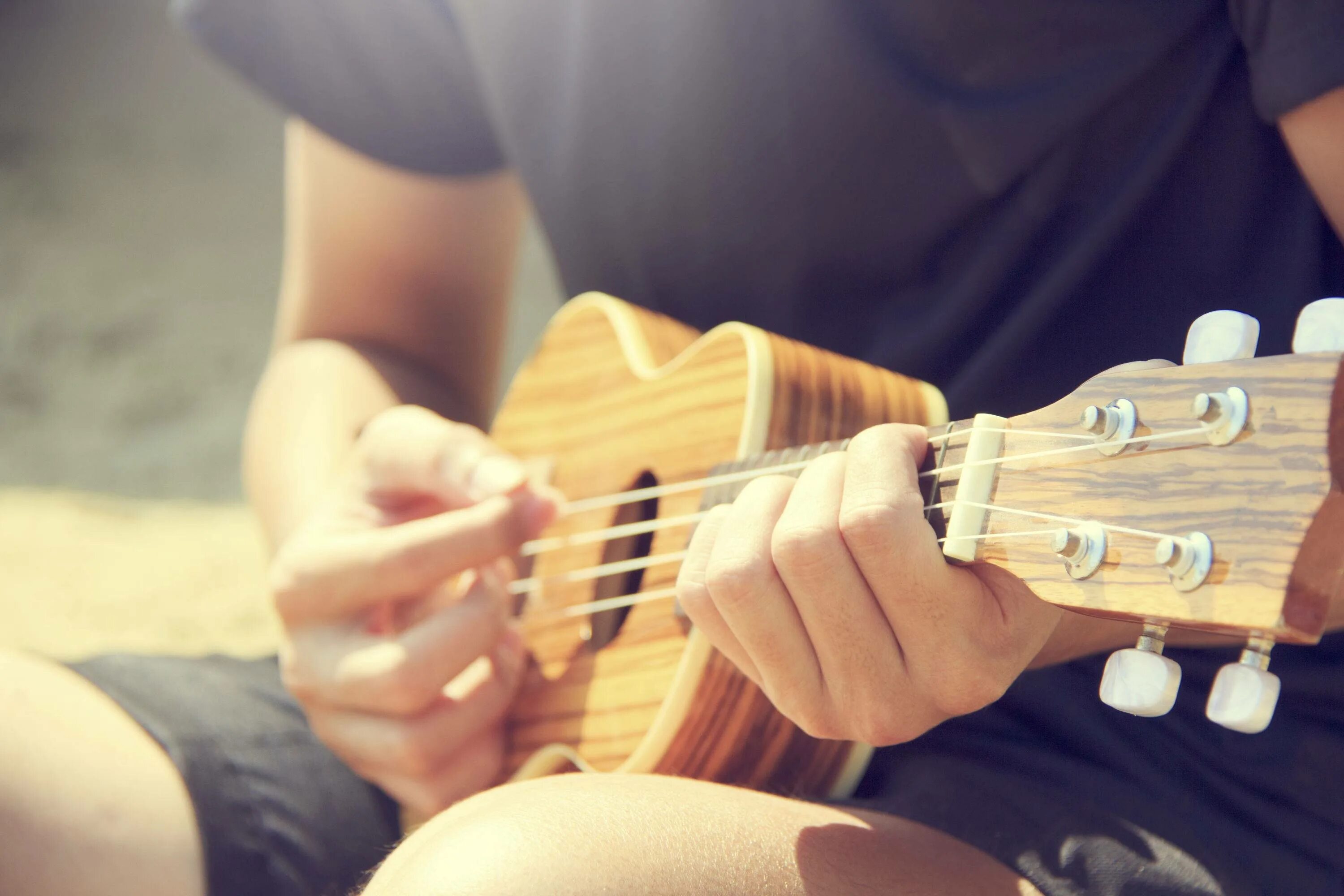 Музыка для игры на музыкальных инструментах. Укулеле в руках. Человек с гитарой. Музыкальный инструмент укулеле. Игра на музыкальных инструментах.