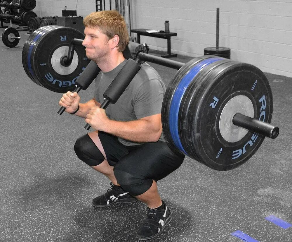 Гриф штанги весит в тренажерном зале. Гриф safety squat bar. гриф хэтфилда для приседаний. присед со штангой. тренажер для становой тяги.