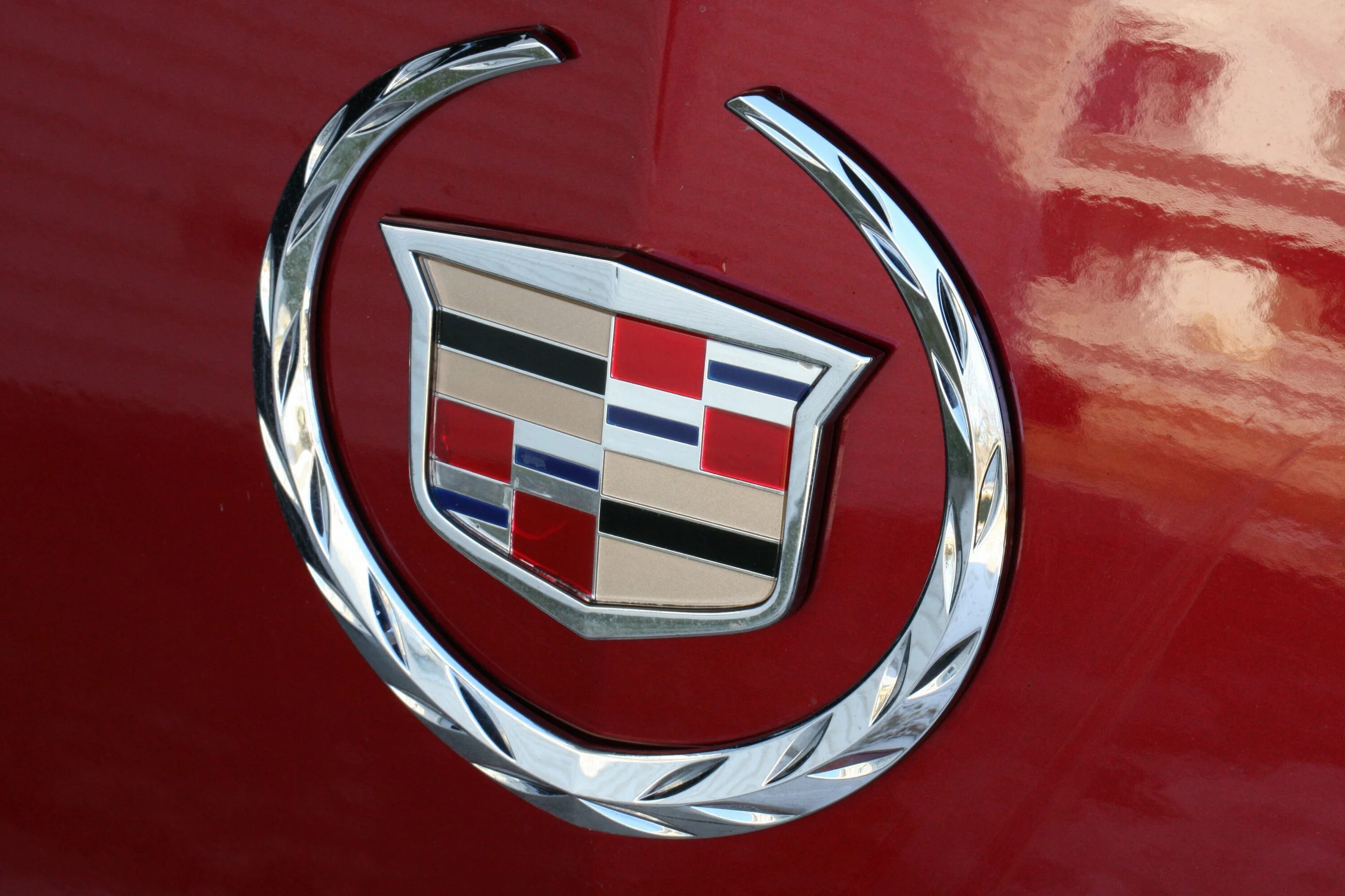 Красный значок автомобиля. Эмблемы автомобилей. Марки автомобилей. Марки авто логотипы. Кадиллак эмблема.