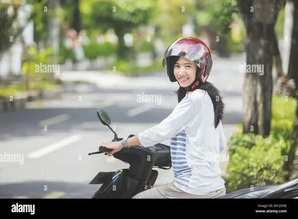 beautiful attractive asian woman riding motorcycle in the city street Stock...