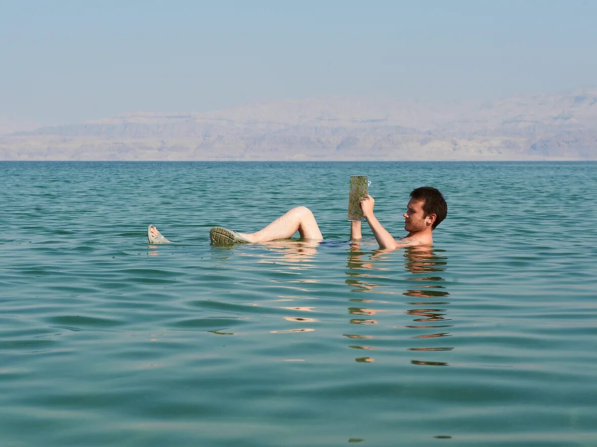 Мертвое море человек на воде. Мертвое море купание. Мёртвое море люди сидят на воде. Мертвое море люди. Мертвое море сидят.