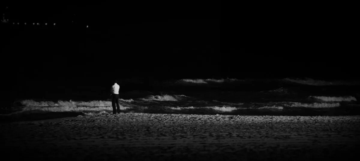 Парень на берегу моря ночью. Мужчина на берегу моря ночью. Море парень ночью. Одинокий человек ночью.
