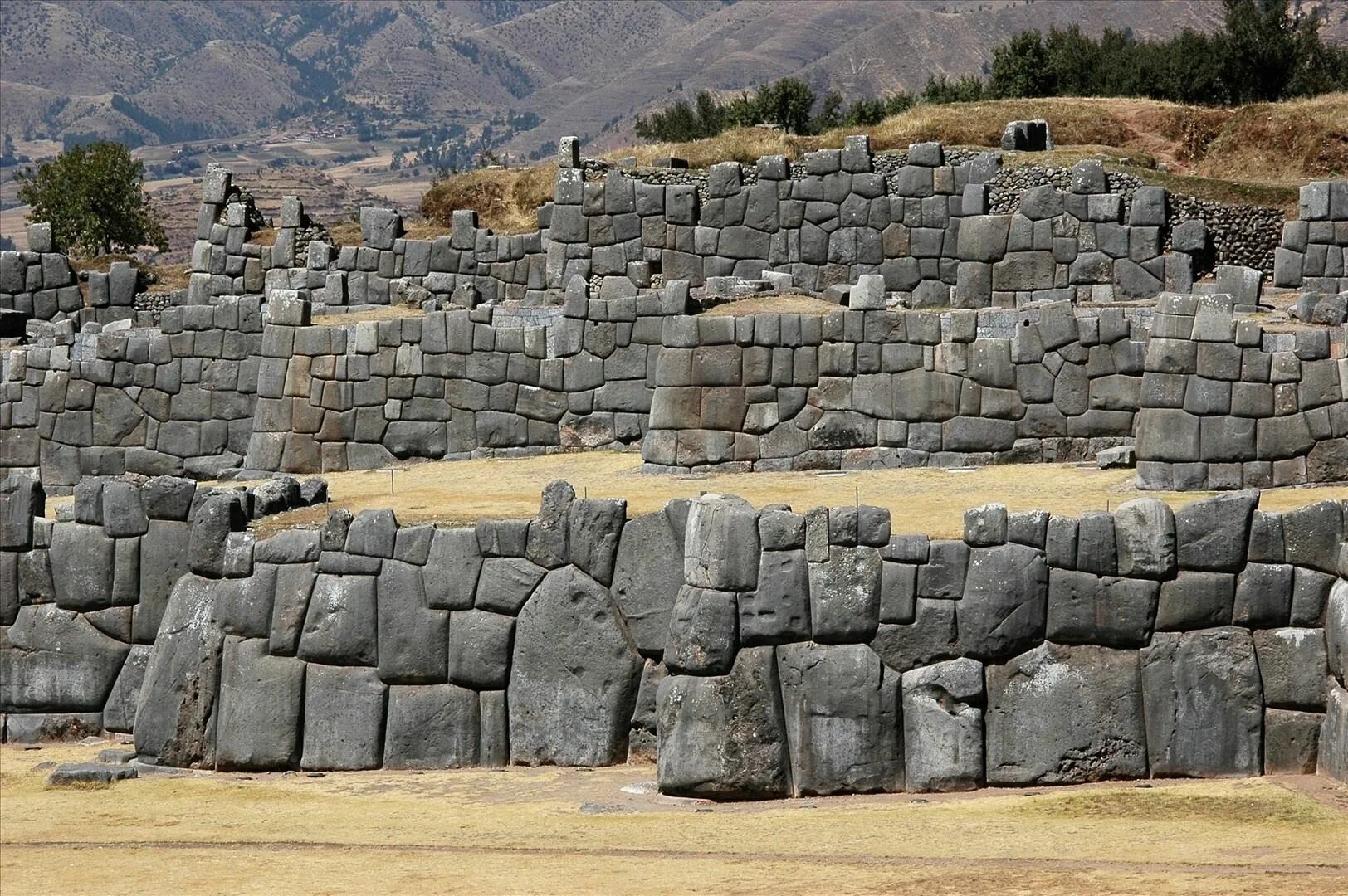 Стоит огромная стена. Храмовый комплекс Саксайуаман, Перу. Крепость инков Саксайуаман. Куско Саксайуаман. Крепость (Пукара) Саскауаман.