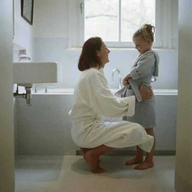 Daughter showers. Daughter in douche. Mom in a bathrobe Home photo.