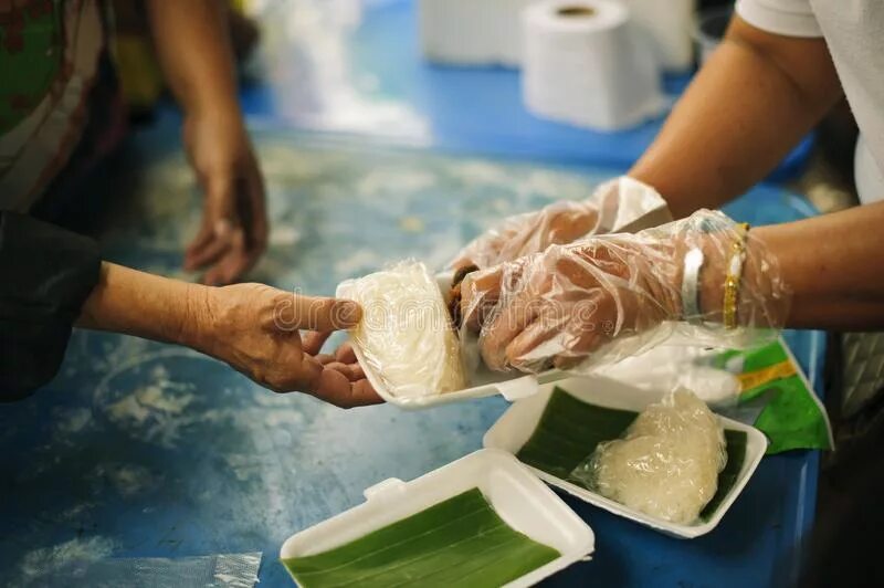 Дает с руки еду. Руки дают еду благотворительность. Рука дает еду. Volunteers provide with food. Еда нищего.