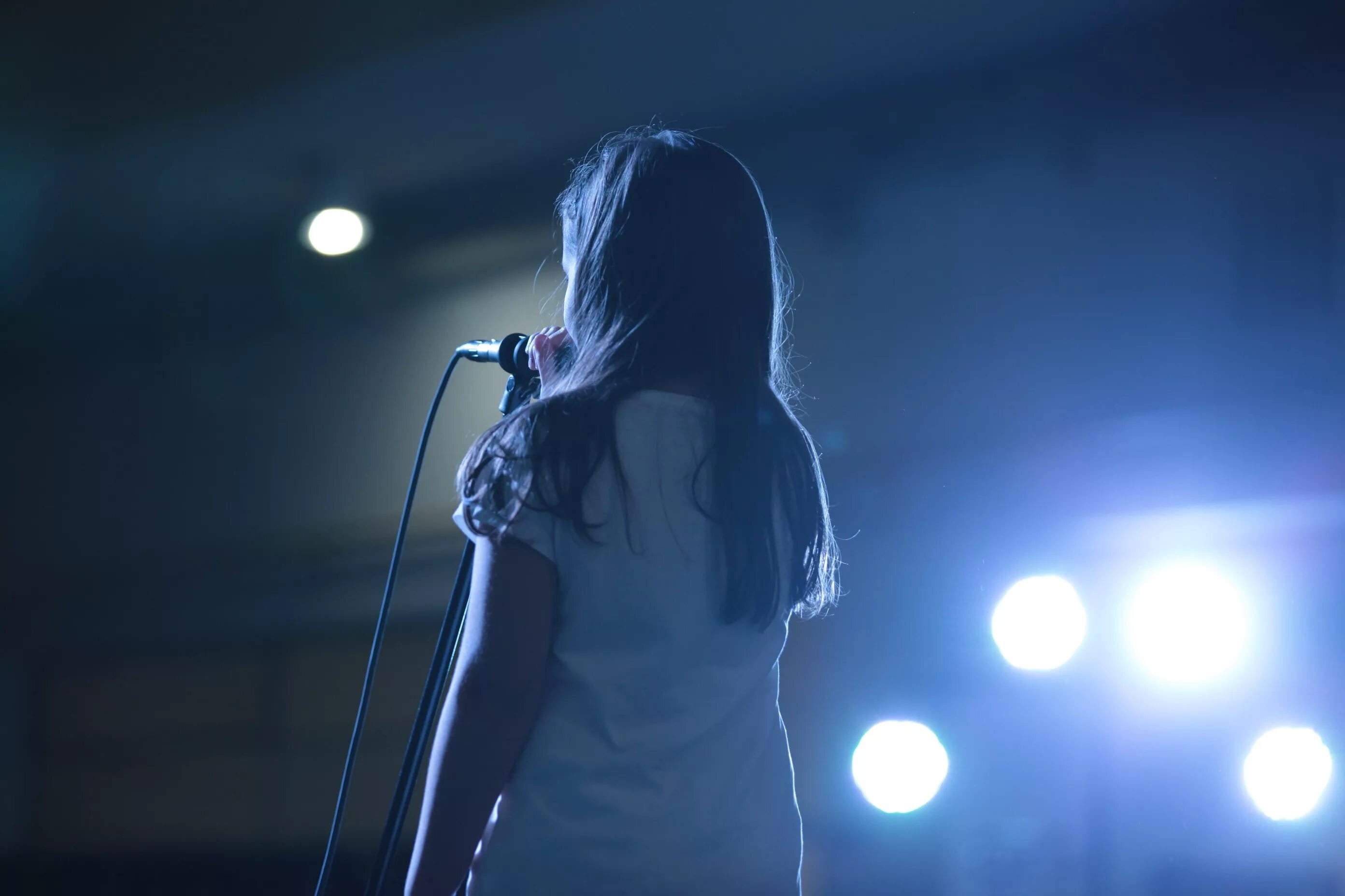 Выступление девочки. Девушка на сцене с микрофоном. Девушка поет на сцене. Девочка поет на сцене. Вокалистка на сцене.