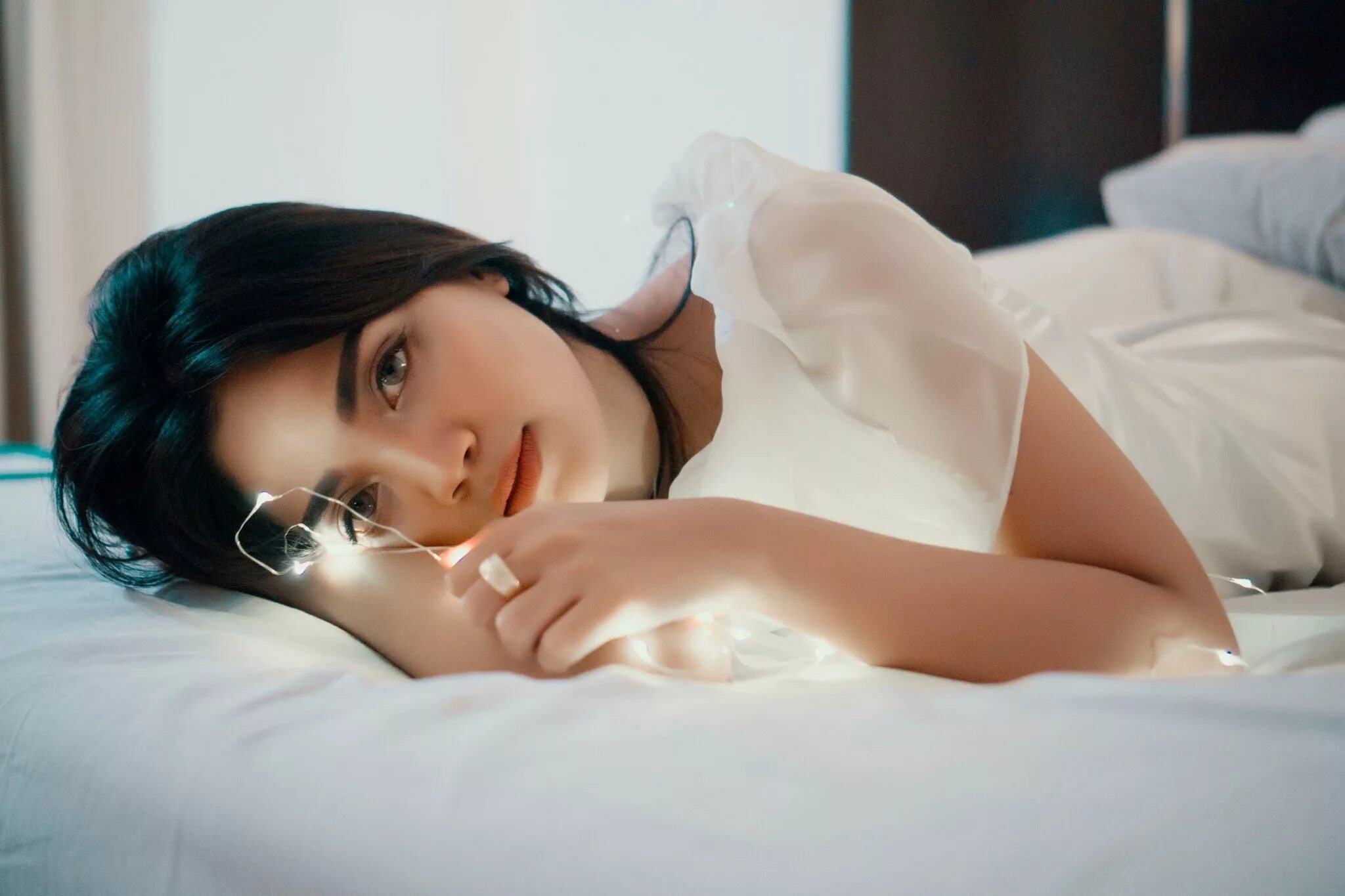 брюнетка со спины на кровати. брюнетка лежит на кровати. брюнетка лежит на кровати. женщина на кровати. михаэла исиззу в шортах.