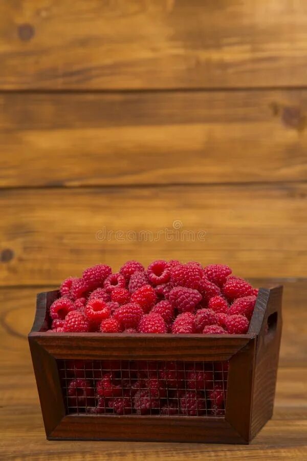 малина в коробочках пластиковых. коробка с малиной на коже.