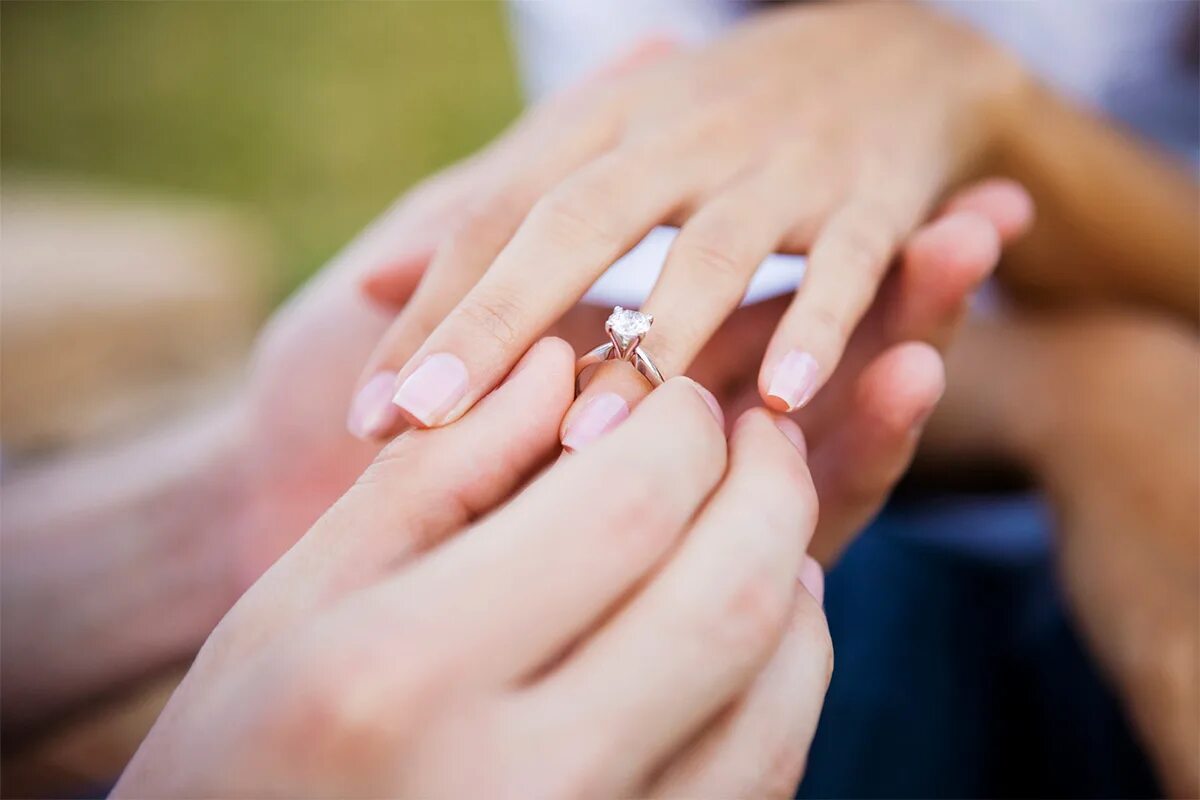 Надевает кольцо. Обручальные и помолвочные кольца. Предложение руки и сердца. Обручальное кольцо на пальце.
