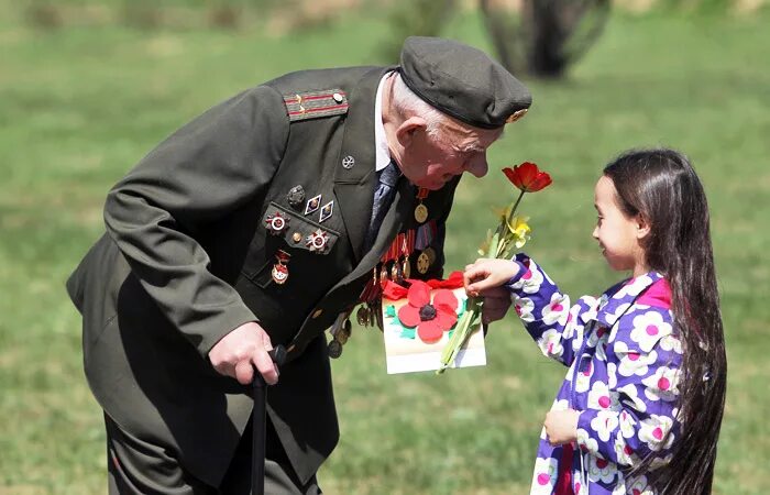 Идти на встречу с ветераном. Девочка дарит цветы ветерану. Дети дарят цветы ветеранам. Цветы ветеранам. Дети вручают цветы ветеранам.