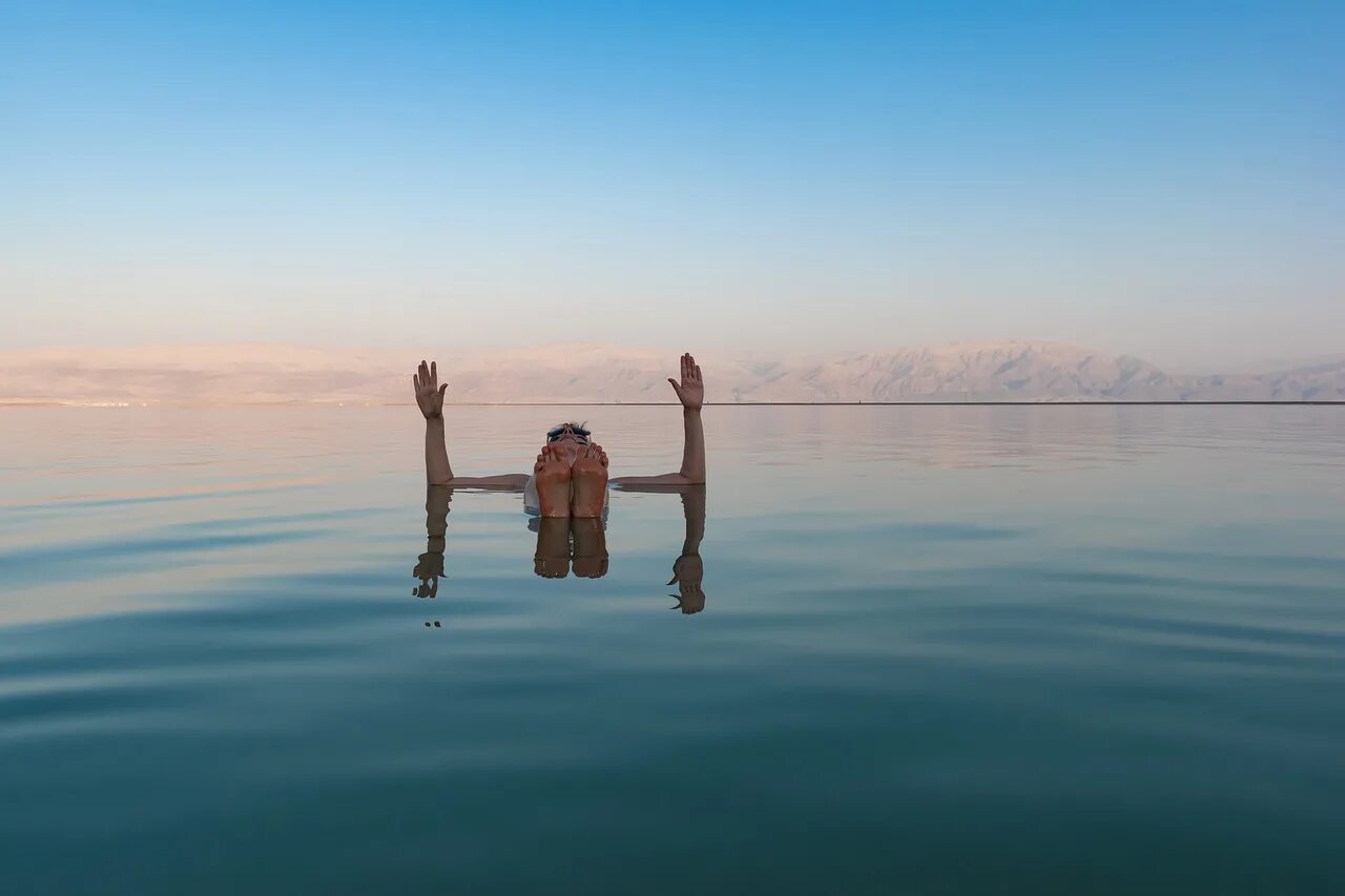 Мертвое море человек на воде. Соленое озеро в Израиле. Мертвое озеро Иордания. Соленое озеро Мертвое море.