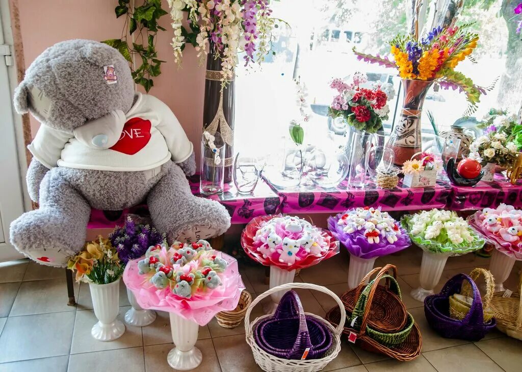 интерьер магазина сувениров. интерьер цветочного магазина. ассортимент магазина цветов и подарков. магазин цветов и игрушек. витрина игрушек в цветочном салоне.
