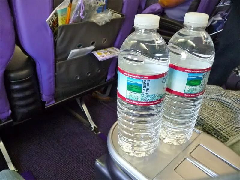 Сок в самолет можно. Жидкости в аэропорту. Бутылка воды в аэропорту. Бутылка питьевой воды в самолете. Жидкость в самолет.