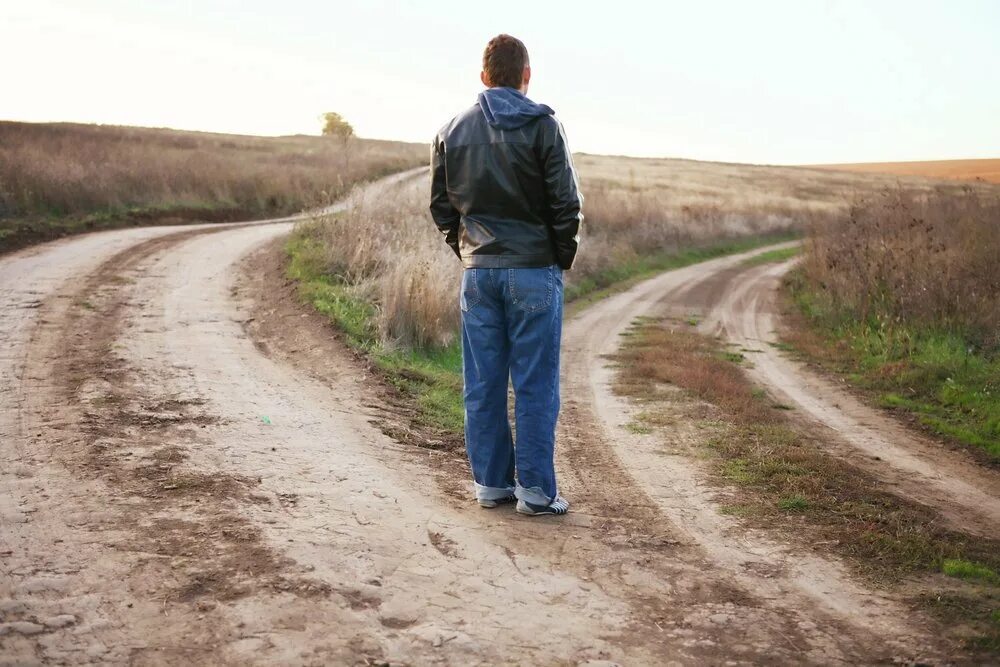 Село никуда. Парень идет по дороге. Человек на дороге. Две дороги. Человек один на дороге.