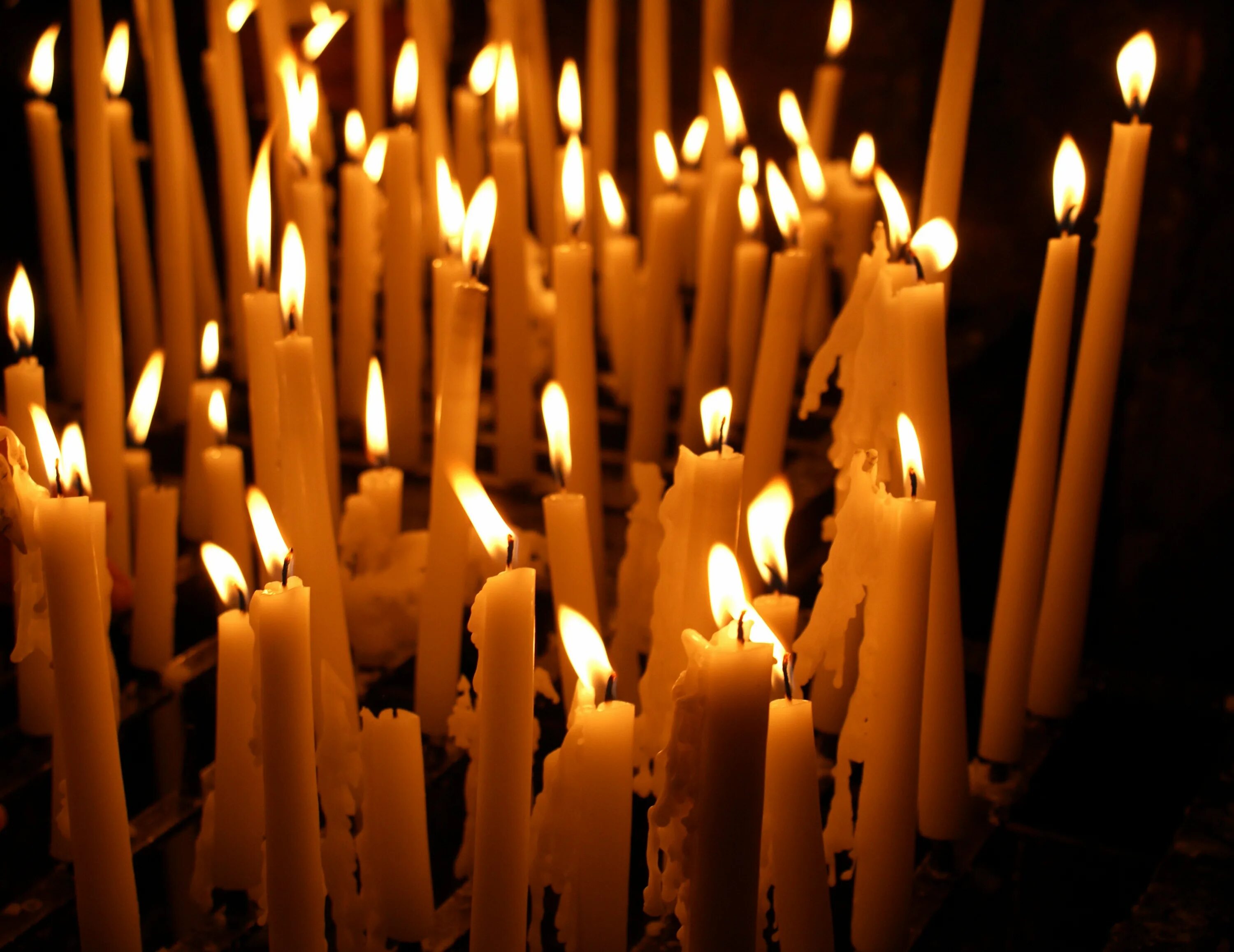 В церкви горят свечи. Свечи в храме. Горящие свечи в церкви. Много свечей. Много свечей в церкви.