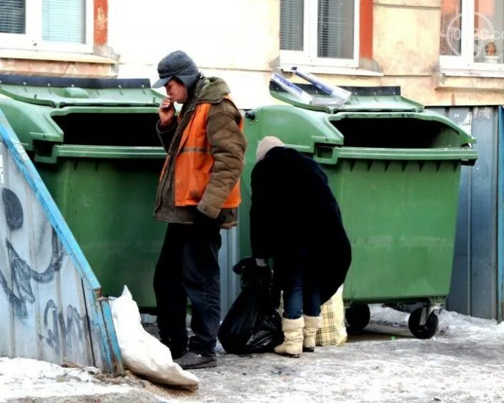 Бомж в мусорном контейнере. Помойка.