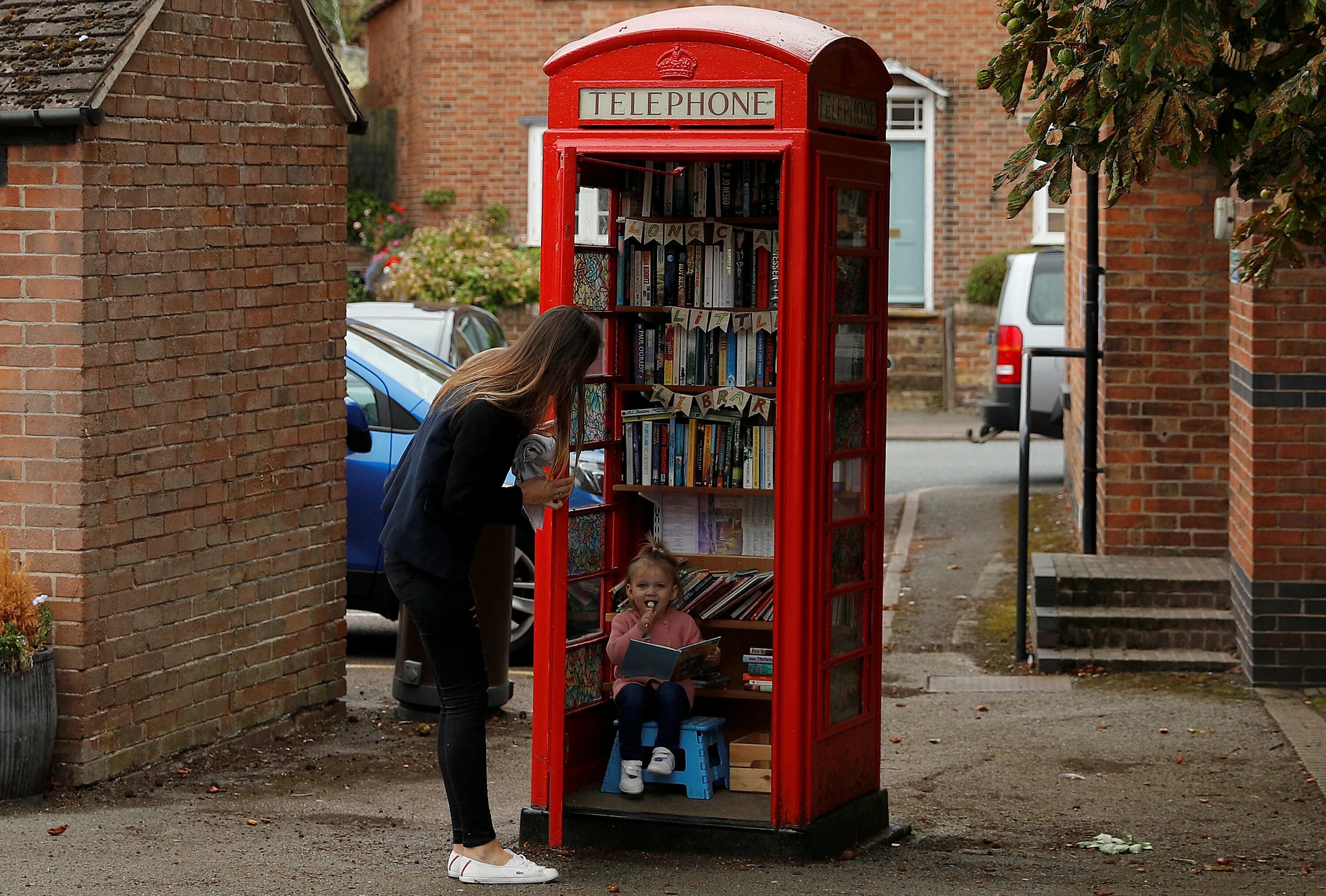Самая маленькая библиотека в мире в Уэстбери саб Мэндип. Библиотека в телефонной будке в Великобритании. Библиотека в телефонной будке. Уличная библиотека.