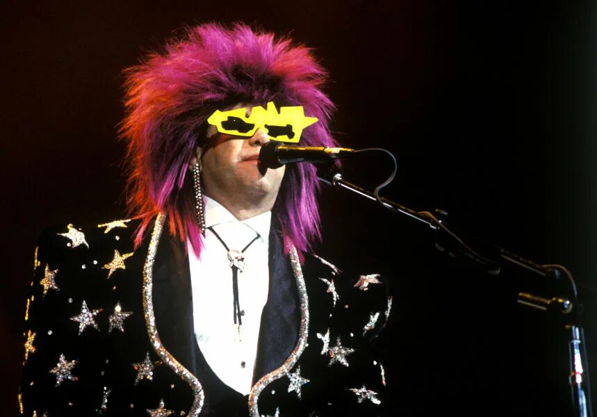 Elton john rock. Элтон Джон глэм рок. Elton John outfits. Зомби Элтон Джон. Элтон Джон в халате.