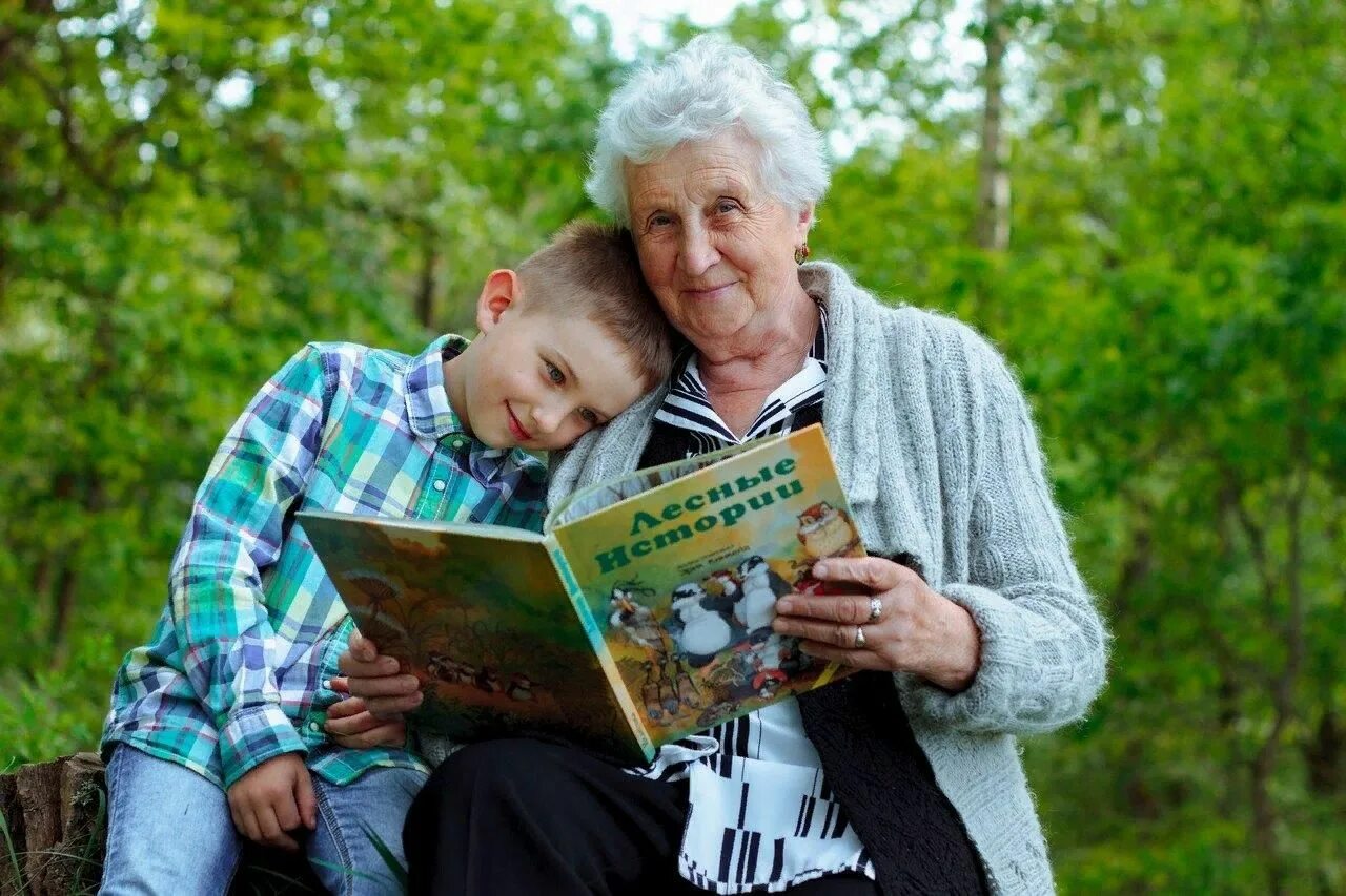 Читатель дедушка. Бабушка с внуками. Пенсионеры с внуками. Бабушка и дедушка. Пожилые люди и дети.