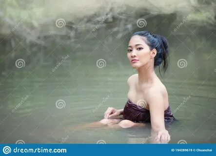 Photo about Portrait of beautiful young Asian woman bathing in the lakeside...