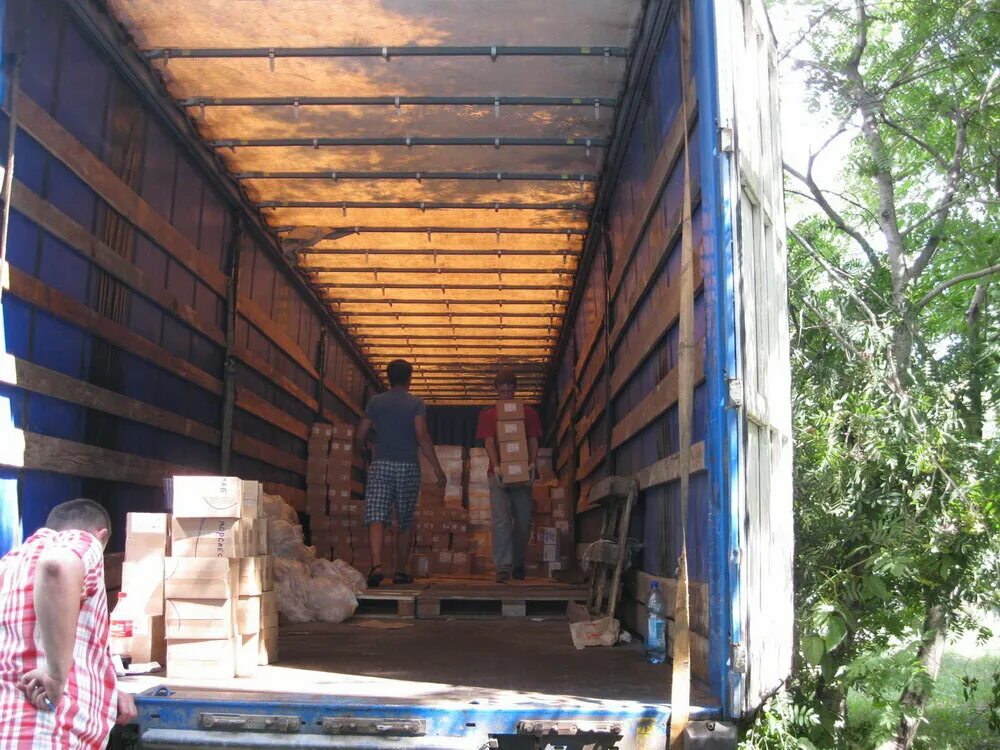 Коробки в кузове грузовика. Машина для перевозки вещей. Разгрузка автомобиля. Разгрузка фур и вагонов. Полуприцеп для перевозки рулонной стали.