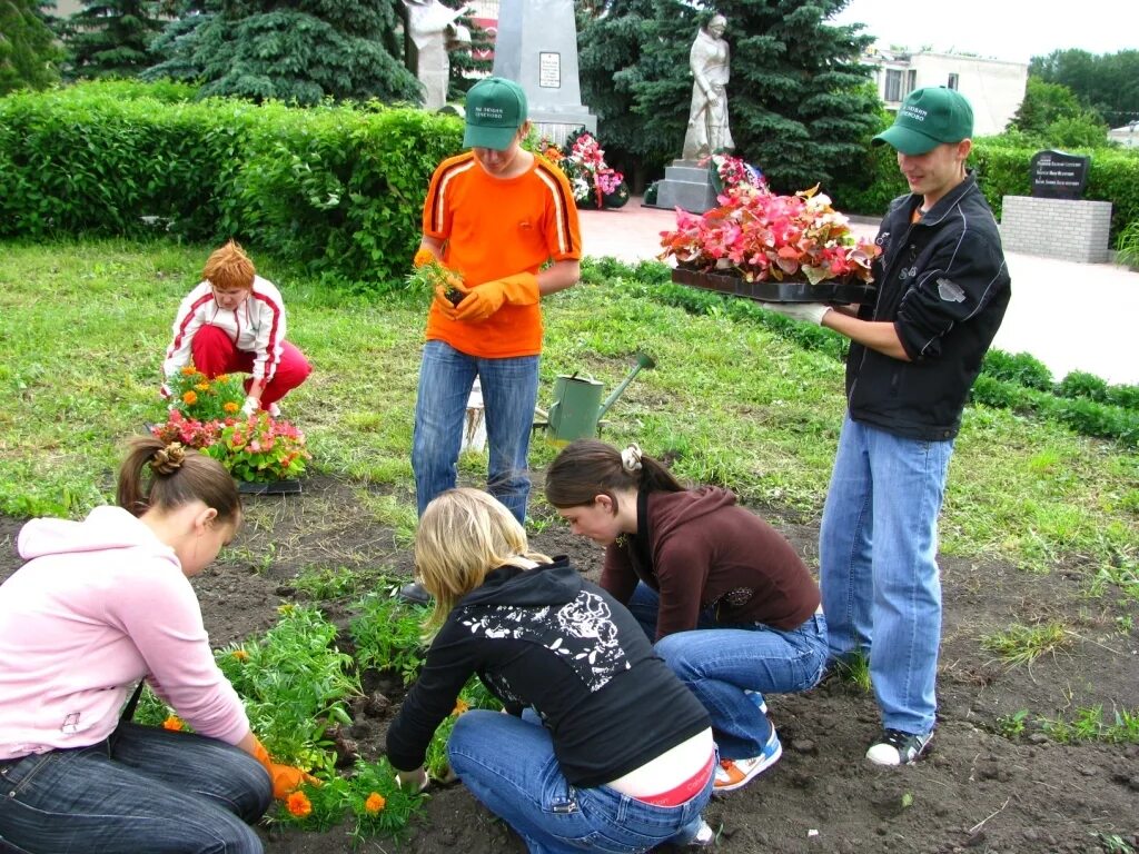 Волонтеры цветы. Посадка цветов волонтерами. Волонтеры высадка растений. Волонтеры сажают цветы. Посадка цветов у памятников.