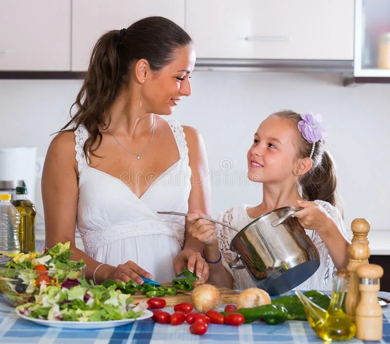 Moms teaching daughter. Мама учит дочь готовить фото.