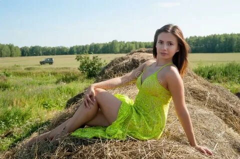 Young beautiful woman relaxes on hay. 