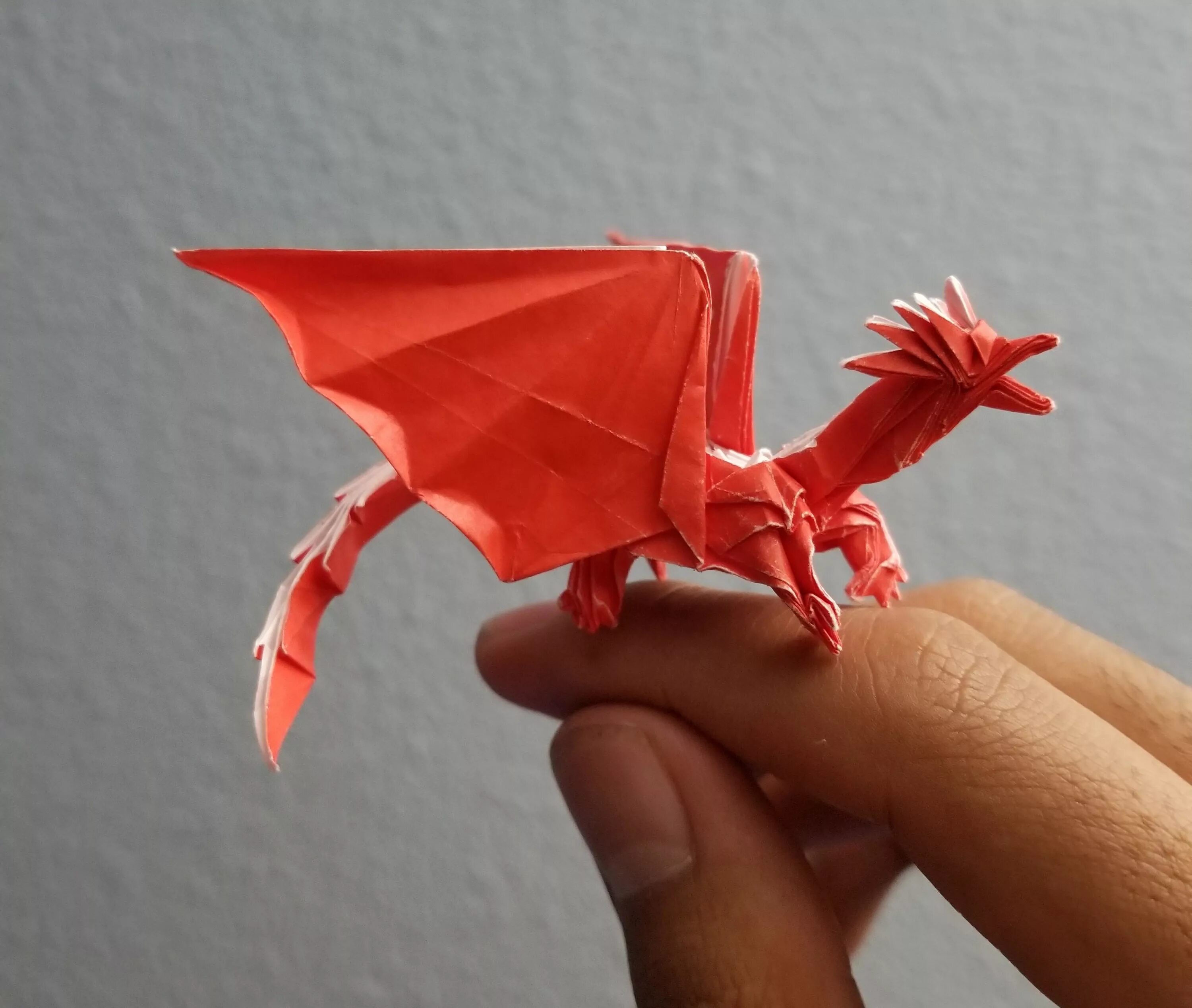 Покажи бумагу дракона. Оригами дракон сатоши Камия. Дракон Корри оригами. Бумажные драконы на руку. Поделка дракон из бумаги.