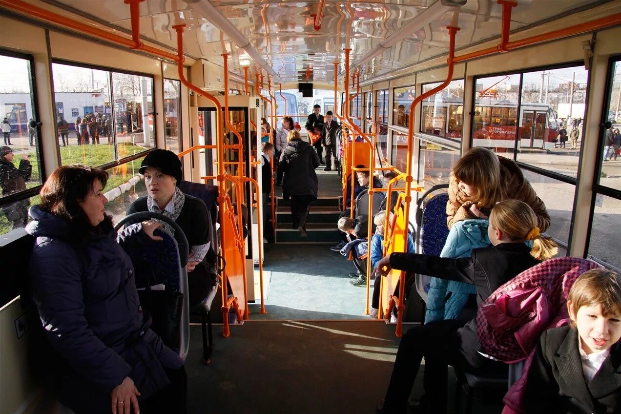 Люди в трамвае. Общественные места. Пассажиры в трамвае. Трамвай внутри с людьми.