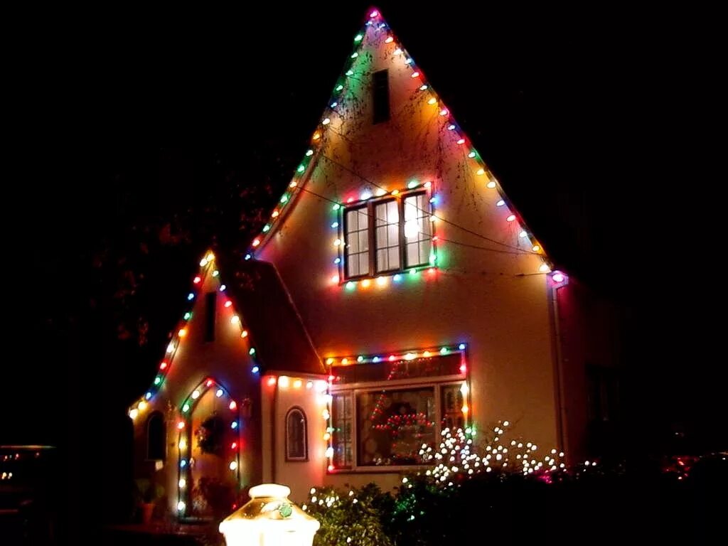 перед домом разноцветные огни. дом украшенный гирляндами на новый год. перед домом разноцветные огни. украшение домов гирляндами. перед домом разноцветные огни.