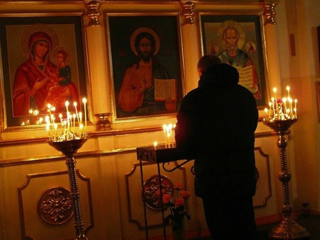 Мужчина молится в храме. Человек в храме перед иконой. Свеча у иконы в храме. Мужчина у иконы в храме. Можно ли молиться перед иконой