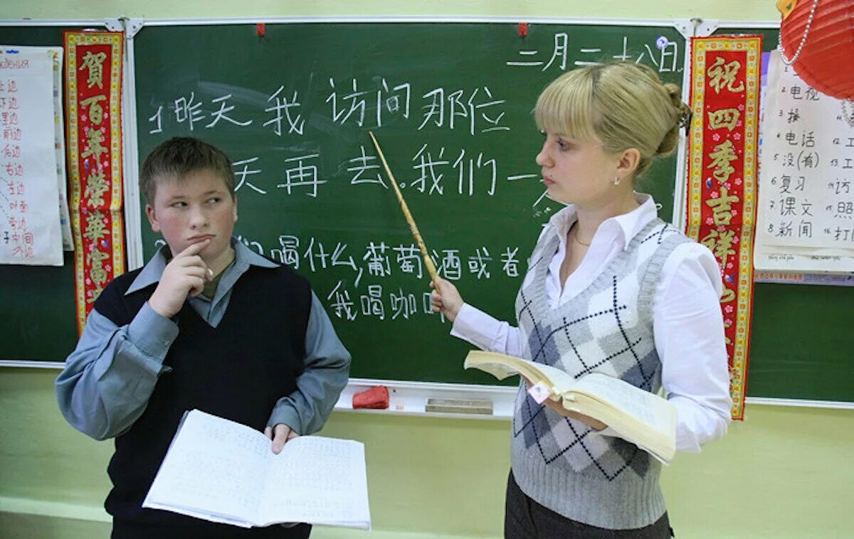 Изучать китайский. Урок китайского. Уроки по китайскому языку. Школьники учат китайский язык. Учитель по китайскому языку.