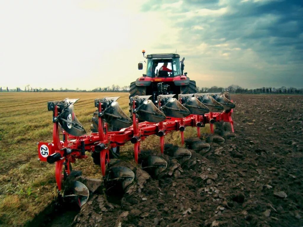 пахота поля на тракторе. пахать землю. трактор с плугом. вспахать поле трактором. вспахать поле трактором.