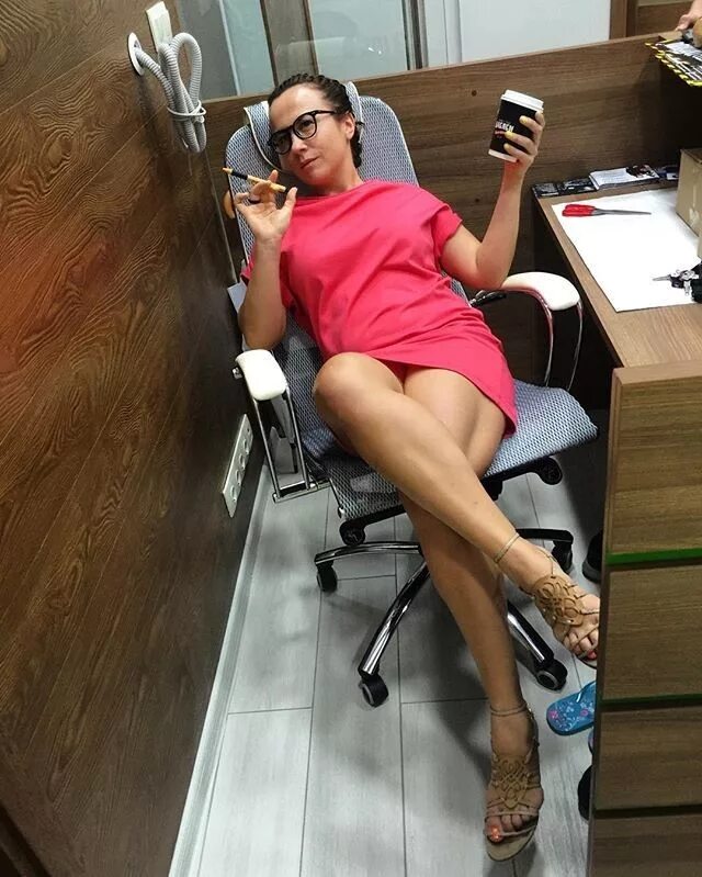 Девушка показывает под столом. Ноги сотрудниц. Под столом в офисе селфи. Секретарша селфи. Девушка на работе
