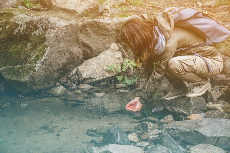 Человек пьет воду из ручья. Пить из ручья. Девушка пьет воду из ручья. Пьет воду из речки.