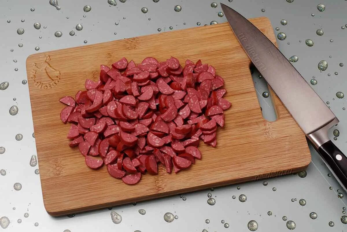 Как нарезать дом. Колбаса нарезанная кубиками. нарезать колбасу овощечисткой. как нарезать колбасу сердечками. колбаса нарезанная кубиками на доске.