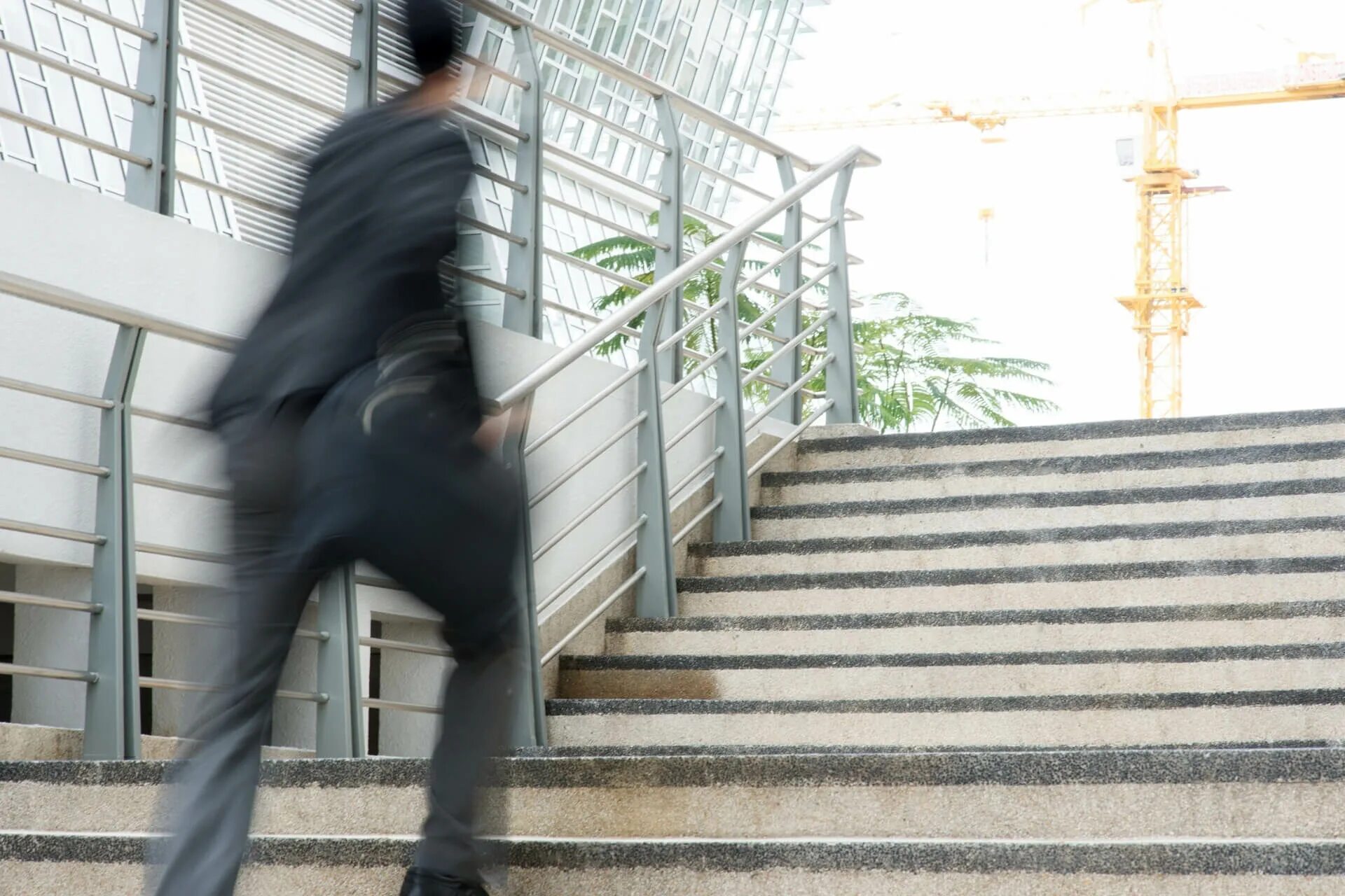 Человек в спешке выбегает из здания. Человек Motion Blur. Офисный сотрудник поднимается по лестнице. Полезно ли подниматься по лестнице.