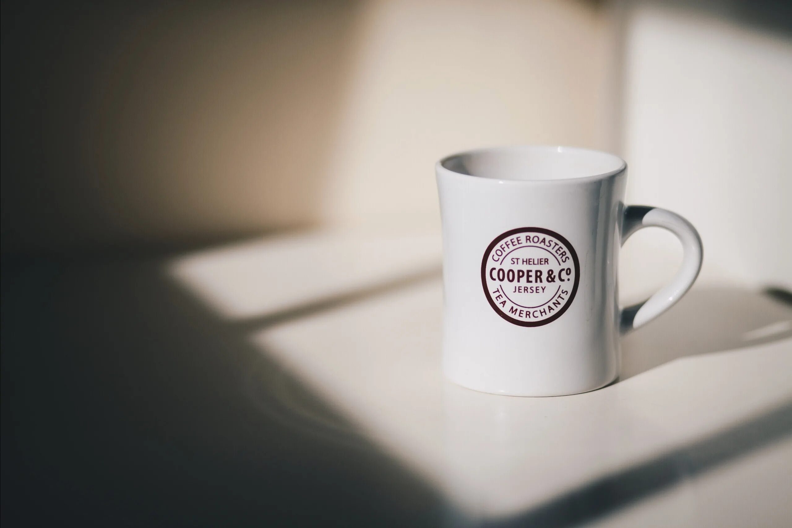 There is a cup on the table. Кружка белая. Стильная белая Кружка. Белая Кружка для фотошопа. Мокапы кружки.