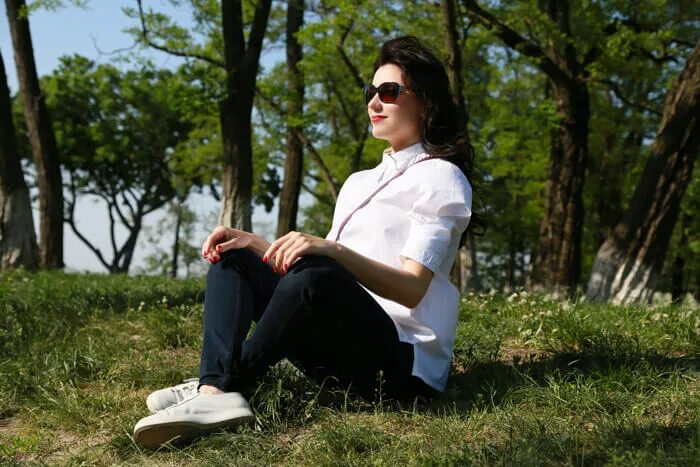 Вконтакте ветров. Девушка в белом свитере сидит на Камне летом фото.