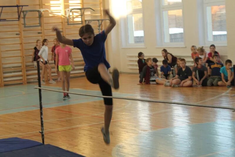 Прыжки в высоту в школе. Прыжки через перекладину в школе. Проведение соревнований в школе по прыжкам в высоту перешагивание. Прыжки физкультура. Соревнования по прыжкам в высоту в школе.