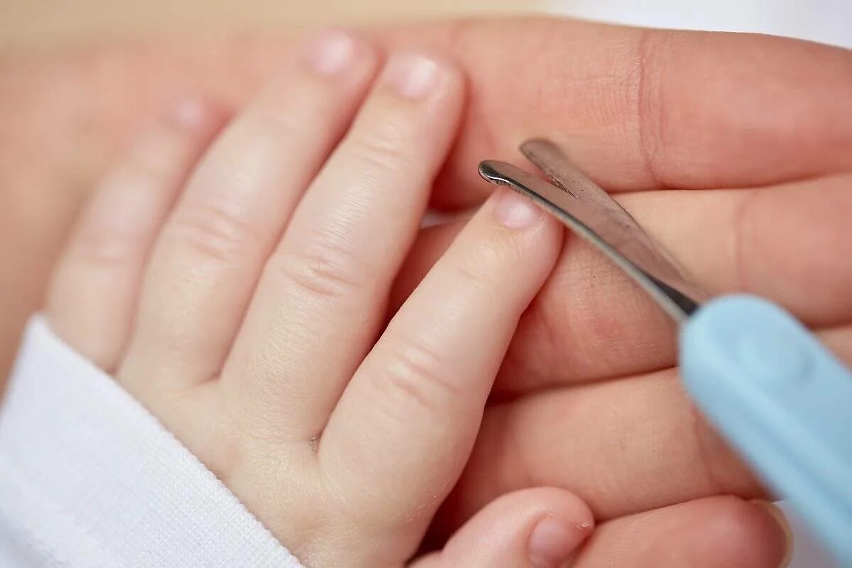 Ребенок подстригает ногти. Стрижка ногтей детям. Стрижка ногтей новорожденному. Подстриженные ногти. В благовещение можно стричь ногти