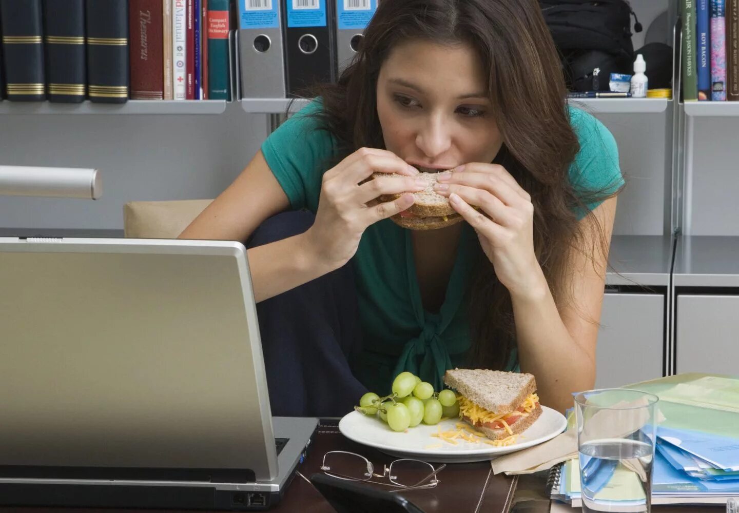 Перекус в офисе. Человек ест за компьютером. Девушка обедает в офисе. Девушка перекус. Обеденный перерыв на работе