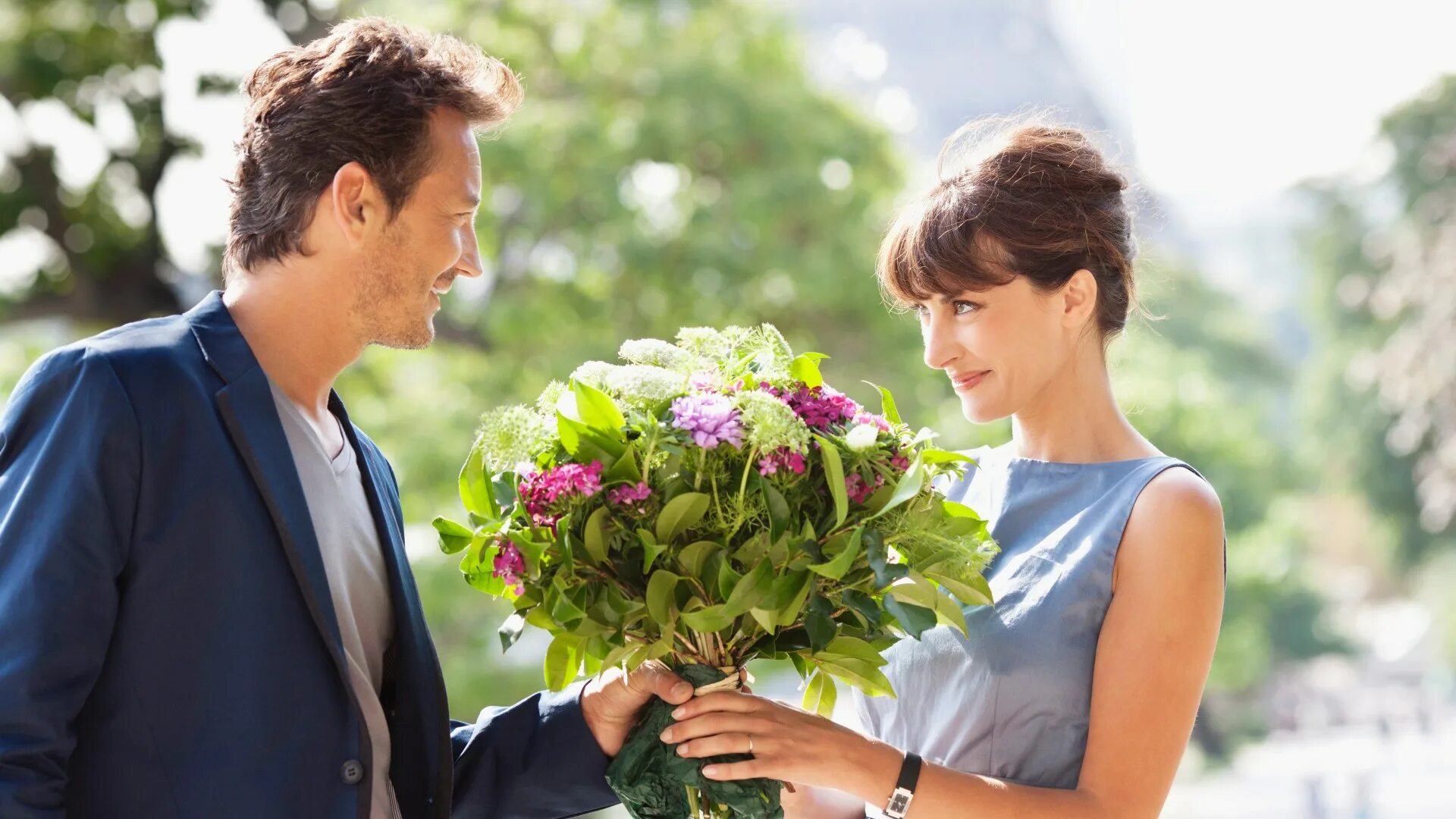 Мальчик дает мужчине. Парень дарит девушке цветы. Мужчина дарит цветы женщине. Мужчина дарит букет цветов. Парень даёт девушке цветы.