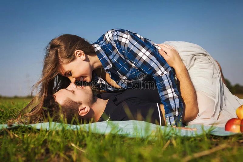 Сверху мужика девушка. Мужчина и женщина лежат на траве. Парень с девушкой обнимаются на траве. Пара на траве вид сверху. Женщина и мужчина лежат на природе.