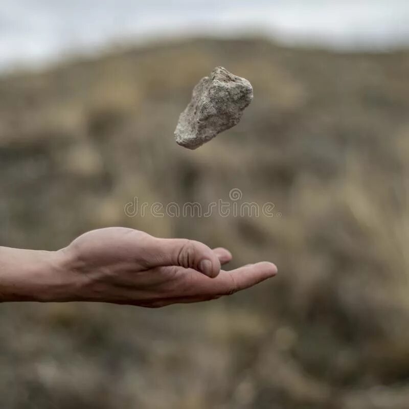 И тогда взяв камень в руку. Камень в руке. камень в руке человека. брошенный камень. булыжник в руке.