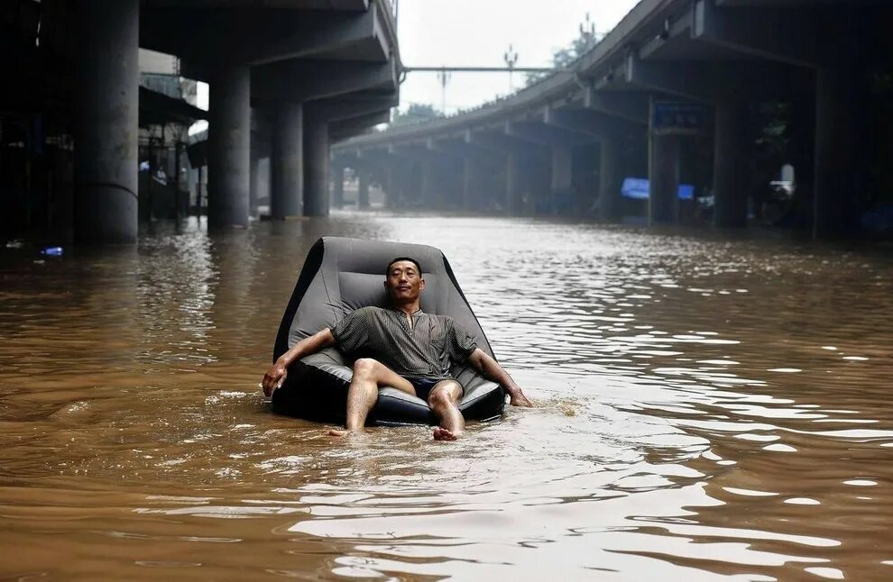 Наводнение. Человек под дождем. Человек сидит в воде.