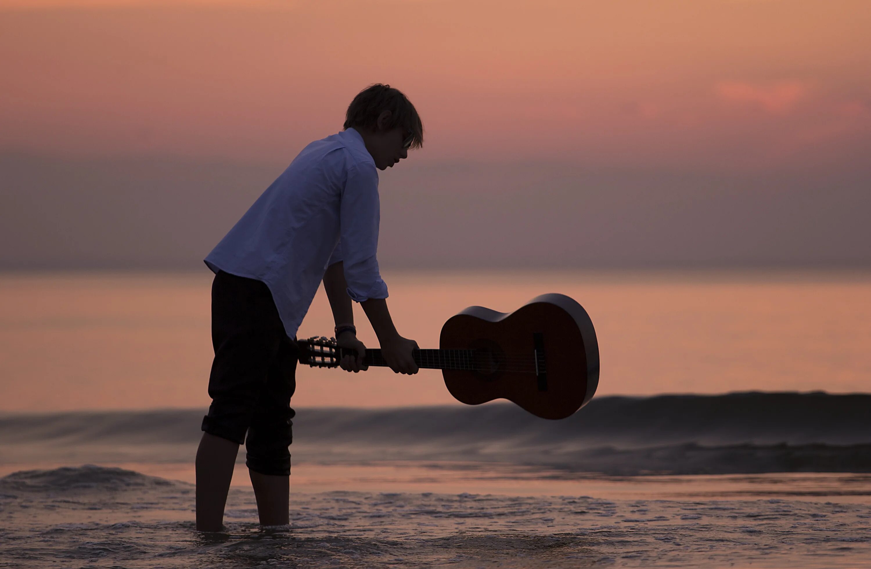 Парень с гитарой у моря. Гитара на берегу моря. Гитарист у моря. Закат на море люди с гитарой.